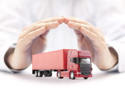 Red long truck with a trailer protected by hands
